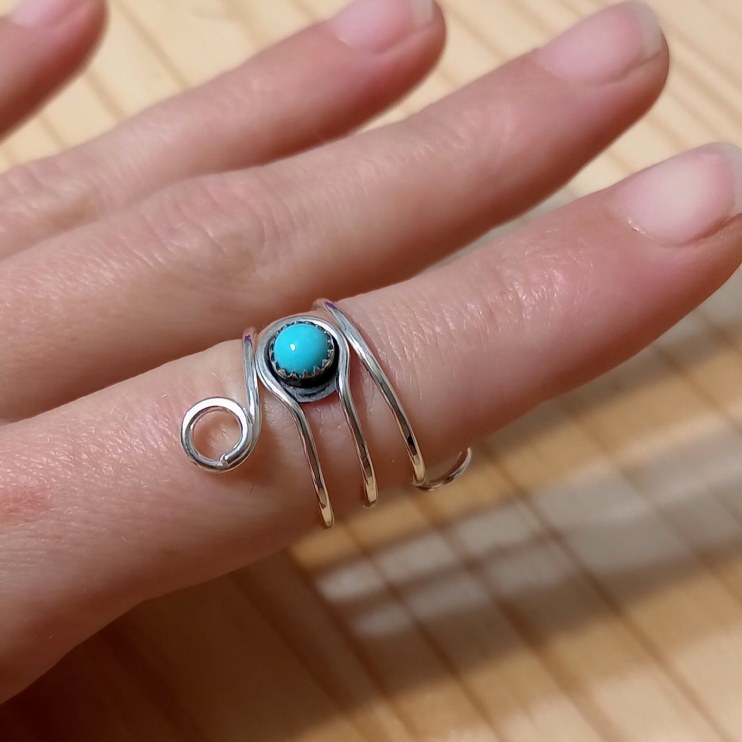 A Sterling silver ring for holding yarn, with a turquoise gemstone.